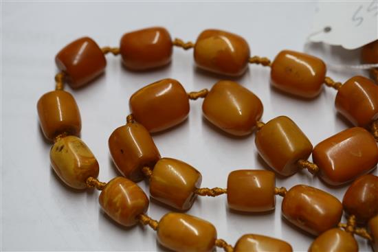 A single strand barrel shaped amber bead necklace, 86cm.